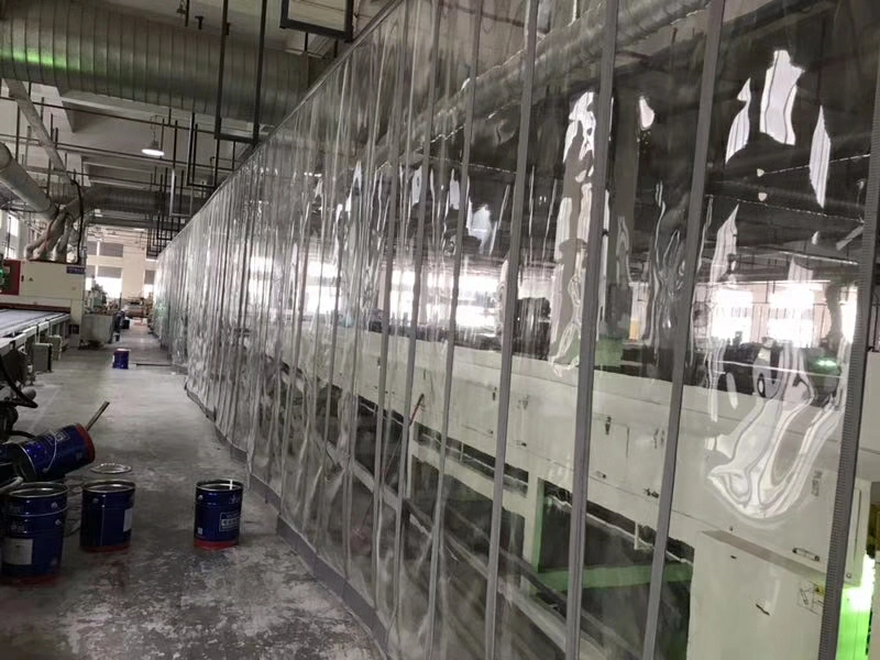 A forklift operator looking through a transparent PVC curtain, demonstrating clear visibility and improved safety.